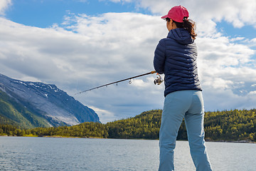 Image showing Woman fishing on Fishing rod spinning in Norway.