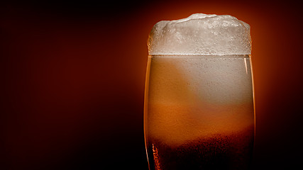 Image showing Lager beer settles in the glass with a white cap of foam