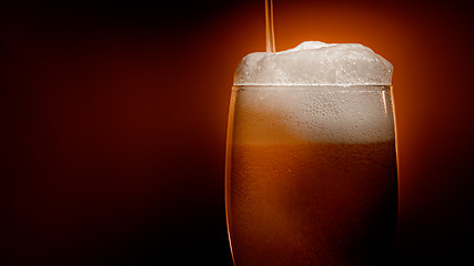 Image showing Lager beer settles in the glass with a white cap of foam