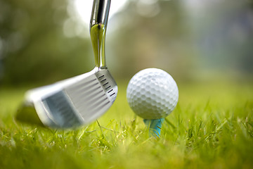 Image showing Golf ball on tee in front of driver