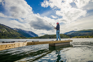 Image showing Woman fishing on Fishing rod spinning in Norway.