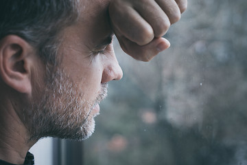 Image showing portrait one sad man standing near a window