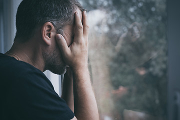 Image showing portrait one sad man standing near a window