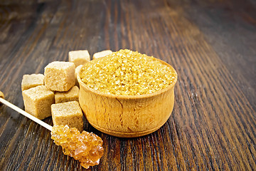 Image showing Sugar brown in bowl on dark wooden board