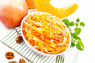 Image showing Salad of pumpkin and apple with nuts in bowl on white board