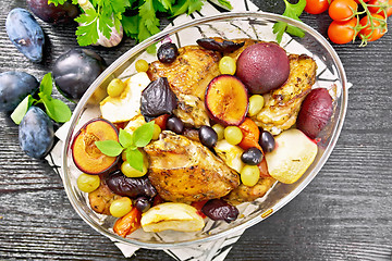 Image showing Chicken with fruits and tomatoes in glass pan on board top