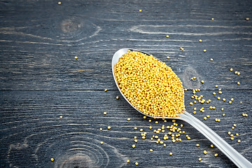 Image showing Mustard seeds in metal spoon on board