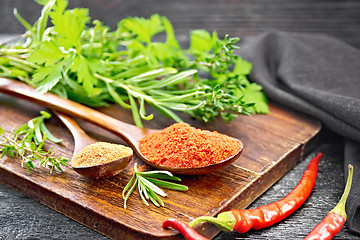 Image showing Peppers red and paprika powder in spoon on black board