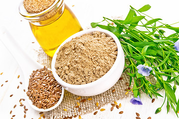 Image showing Flour linen in bowl with seeds and oil on wooden board