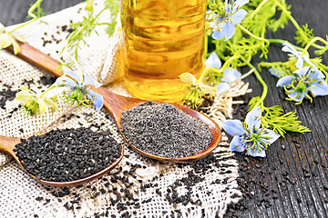 Image showing Flour and seeds of kalingi in spoons on old board