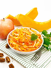 Image showing Salad of pumpkin and apple with nuts in bowl on board