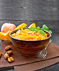 Image showing Salad of pumpkin and apple with nuts in bowl on dark board