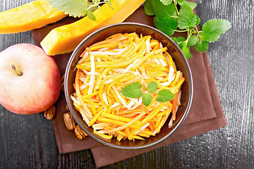 Image showing Salad of pumpkin and apple in bowl on dark board top