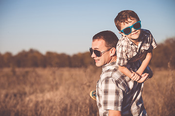 Image showing Father and son playing on the field at the day time.