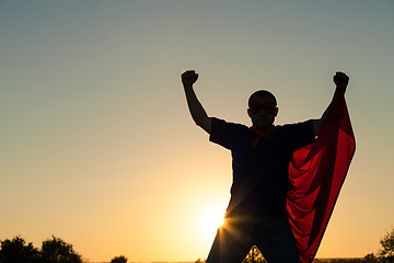 Image showing One man playing superhero at the sunset time