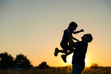 Image showing Father and son playing in the park at the sunset time.