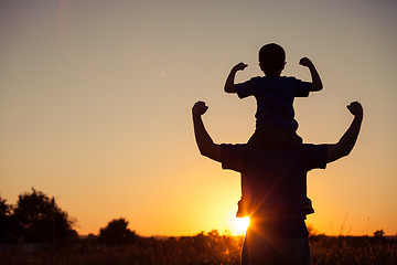 Image showing Father and son playing in the park at the sunset time.