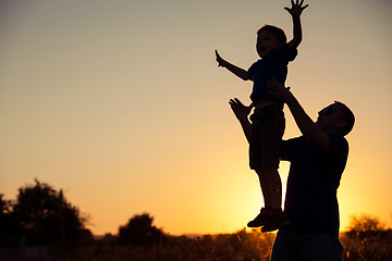 Image showing Father and son playing in the park at the sunset time.