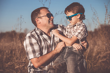 Image showing Father and son playing on the field at the day time.