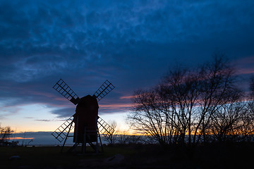 Image showing Old windmill silhouette by a cloudy sky