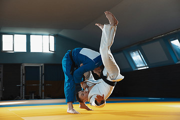 Image showing Two young judo fighters in kimono training martial arts in the gym with expression, in action and motion