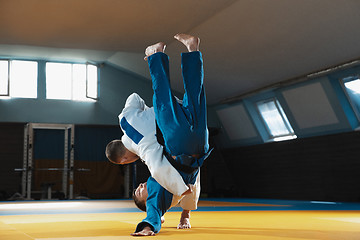 Image showing Two young judo fighters in kimono training martial arts in the gym with expression, in action and motion