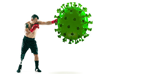 Image showing Professional sportsman kicking, punching coronavirus model - fight the desease, flyer