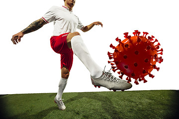 Image showing Football or soccer player kicking, punching model of coronavirus - fighting with epidemic concept