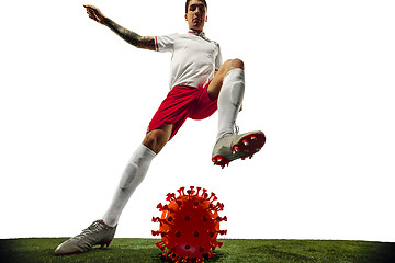 Image showing Football or soccer player kicking, punching model of coronavirus - fighting with epidemic concept