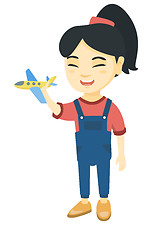 Image showing Asian cheerful girl playing with a toy airplane
