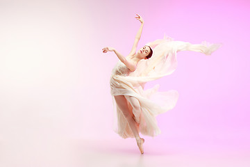 Image showing Ballerina. Young graceful female ballet dancer dancing over pink studio. Beauty of classic ballet.