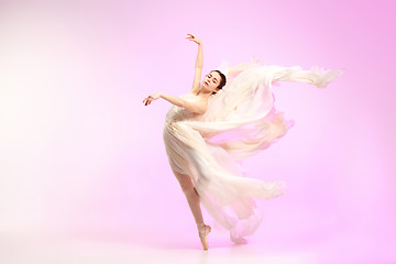 Image showing Ballerina. Young graceful female ballet dancer dancing over pink studio. Beauty of classic ballet.