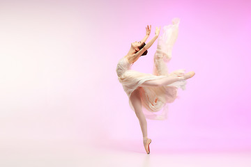 Image showing Ballerina. Young graceful female ballet dancer dancing over pink studio. Beauty of classic ballet.