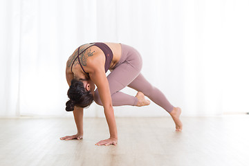 Image showing Portrait of gorgeous active sporty young woman practicing yoga in studio. Beautiful girl practice Sasangasana, rabbit yoga pose. Healthy active lifestyle, working out indoors in gym