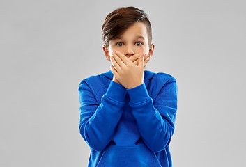 Image showing shocked boy closing mouth by hands