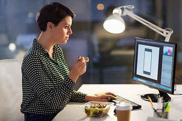 Image showing designer eating and working at night office