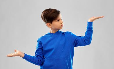 Image showing boy in blue holding something on empty hands