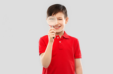 Image showing smiling boy looking through magnifying glass