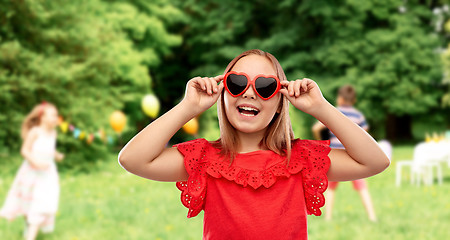 Image showing happy girl with heart shaped sunglasses at party