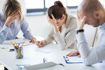 Image showing stressed business team with papers at office