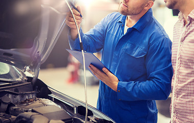 Image showing auto mechanic with clipboard and man at car shop