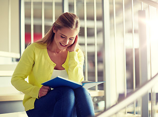 Image showing smiling high school student girl reading book