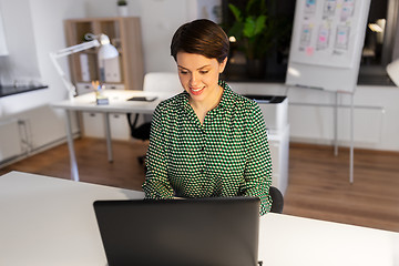 Image showing businesswoman working on laptop at night office