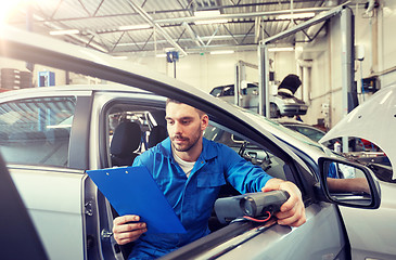 Image showing mechanic man with diagnostic scanner at car shop