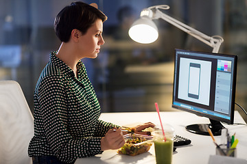 Image showing designer eating and working at night office