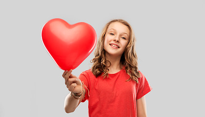 Image showing smiling teenage girl with red heart shaped balloon