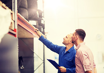 Image showing auto mechanic with clipboard and man at car shop