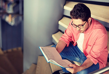 Image showing student boy or young man reading book at library