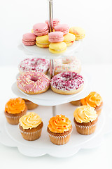 Image showing glazed donuts, cupcakes and macarons on stand