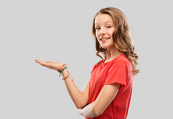 Image showing smiling teenage girl holding empty hand